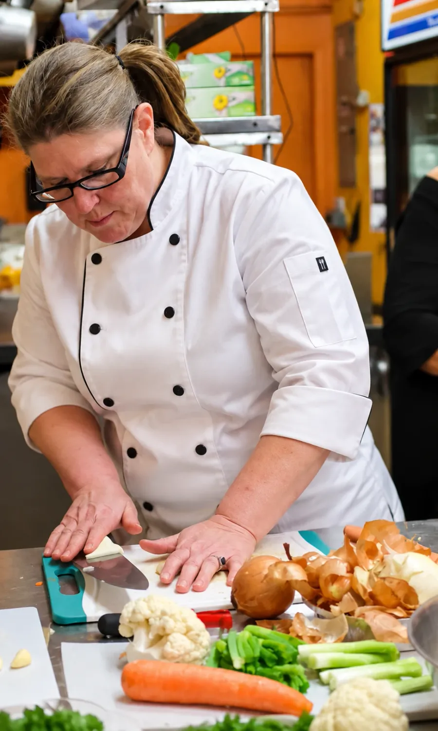 Chef Teey prepping fresh vegetables in her kitchen